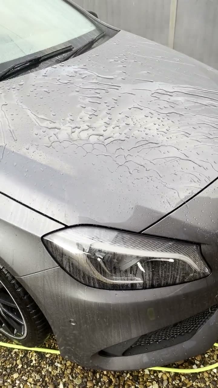 Water beading and running off the bonnet of a silver Mercedes protected with a spray ceramic sealant